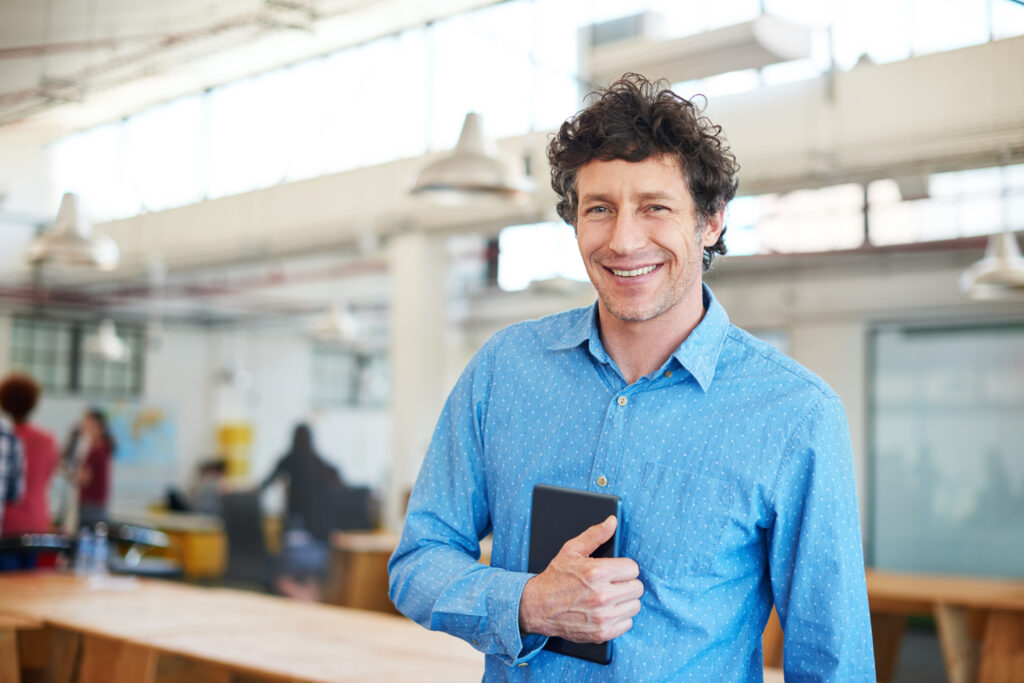 Modern business. Cropped shot of a handsome businessman working in the office with his colleagues in the background.